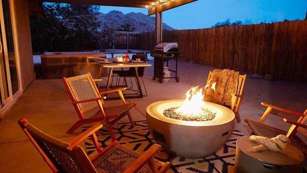 An outdoor patio with a fire pit, seating, and a barbecue grill. - Live Centered W/ Hot Tub, Fire Pit In Joshua Tree 2 Bedroom Home by RedAwning (Joshua Tree)
