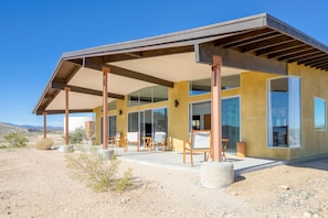 Enjoy outdoor dining or relaxation on the covered patio with comfortable seating and large windows for a bright interior.