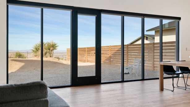 A modern interior with a large sliding glass door leading to an outdoor patio area. - Back Haus - Views, Dark Skies And Fire Pit! 1 Bedroom Home by RedAwning (Joshua Tree)