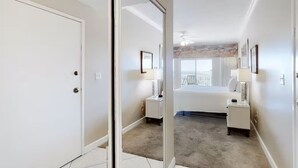 A bedroom with a bed, bedside tables, a mirror, and a window. - Tops'l 1008a Chalet by RedAwning (Miramar Beach)