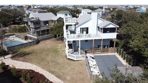 A two-story house with a large deck and a swimming pool. - OBXLanai - 5 houses from Private Duck Beach + Private Pool at House! (Kitty Hawk)