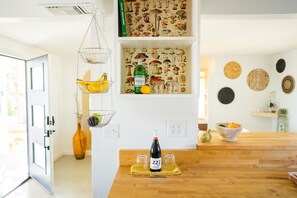 Enjoy cooking and dining in this kitchen with a wine bottle, wine glasses, and fresh fruits on display.