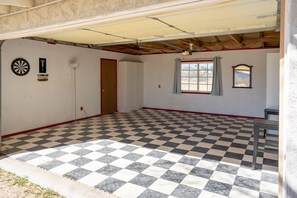 Classic room with a checkered floor, single door, and window offering a view of the outdoors.