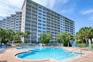 Guests can enjoy a refreshing swim in the hotel's pool surrounded by lounge chairs and a lush palm tree-lined area.