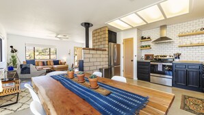 Una cocina moderna con chimenea de ladrillo, electrodomésticos de acero inoxidable y una mesa de comedor de madera.