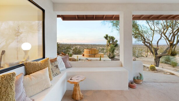 A modern outdoor seating area with a sofa, cushions, and a wooden table. - Terracasa - Hot Tub, Fire Pit, Outdoor Shower & Endless Views 2 Bedroom Home by RedAwning (Yucca Valley)