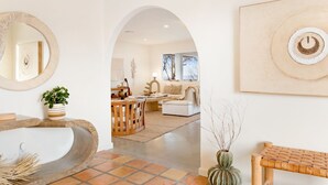 A spacious living area with a large window, a fireplace, and a cozy seating arrangement. - Terracasa - Hot Tub, Fire Pit, Outdoor Shower & Endless Views 2 Bedroom Home by RedAwning (Yucca Valley)