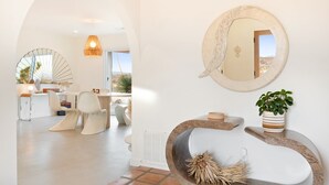 A modern interior with a dining area, a round mirror, and a potted plant. - Terracasa - Hot Tub, Fire Pit, Outdoor Shower & Endless Views 2 Bedroom Home by RedAwning (Yucca Valley)