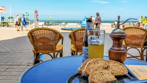 Taula amb una ampolla de Blanche de Namur, trossos de pa i un molinet de pebre.