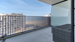 Un balcó amb vistes a una platja i edificis.