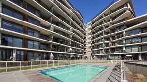 Un hotel modern d'àmbit vertical amb una piscina central envoltada de balcons.
