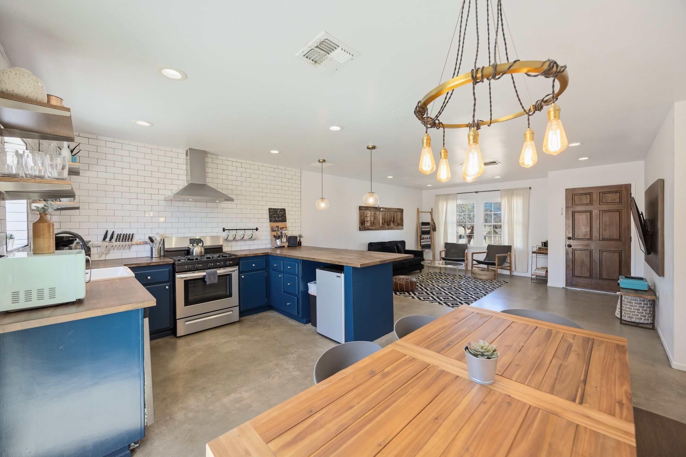 A modern kitchen with a central island, built-in appliances, and pendant lighting.