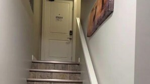 A staircase with stone steps and a white handrail leading to a door with a sign. - Grande Royale (Saskatoon)