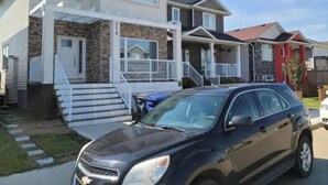 A modern two-story house with a front porch and a driveway. - Grande Royale (Saskatoon)