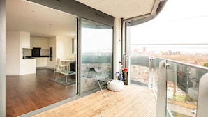 A modern apartment with a balcony, a dining area, and a kitchen. - Remarkable 2-bed Apartment in London Amazing Views (London)
