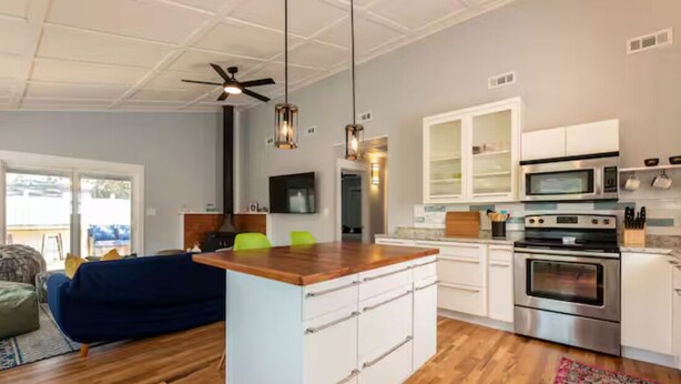 A modern kitchen with white cabinetry, a central island, and stainless steel appliances.