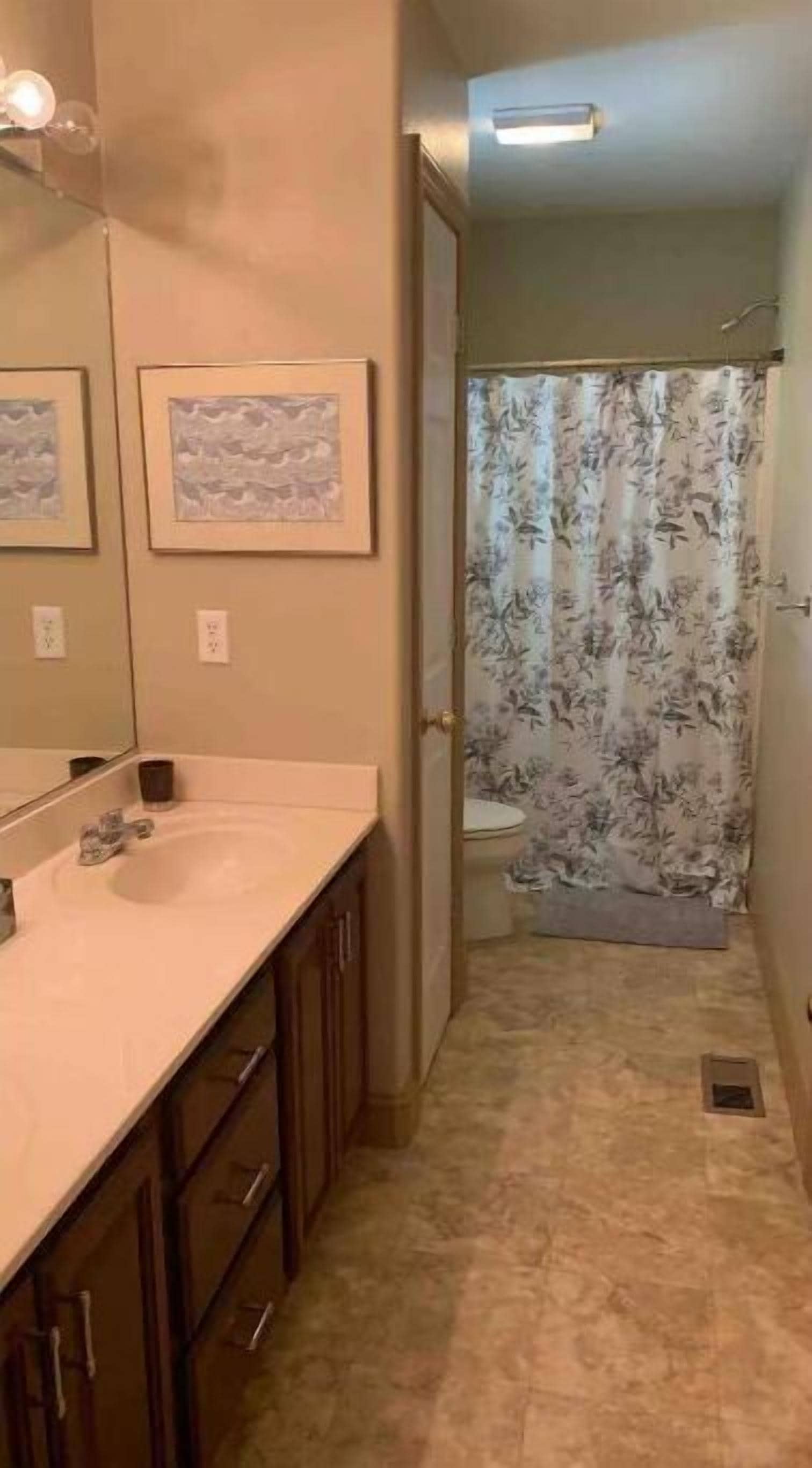 Une salle de bain avec un lavabo, un miroir et des toilettes.