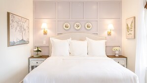 A neatly arranged bedroom with a bed, two bedside tables, wall-mounted lamps, and decorative plates. - Kildahl House - Boutique Farmhouse Suite #3 (West Dundee)