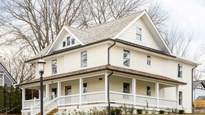 A two-story house with a front porch, multiple windows, and a chimney. - Kildahl House - Boutique Farmhouse Suite #3 (West Dundee)