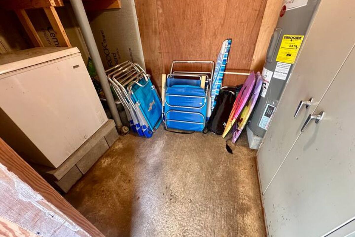Habitación compacta con kitchenette, un mueble pequeño y un estante en la pared con bolsas azules.