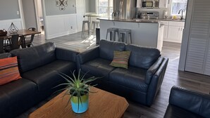 A modern living room with a leather sofa, a coffee table, and a potted plant.