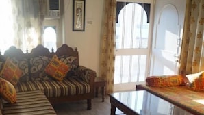 Una sala de estar con un sofá, una mesa de centro y un tapete estampado.