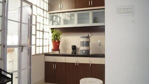 Una cocina con armarios de madera oscura, una planta en maceta y una cafetera.