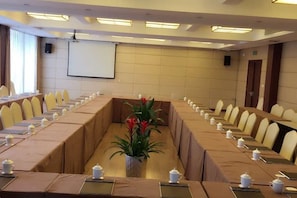 A conference room with a long table, chairs, and a projector screen. - Guorui Hotel (Jiande)