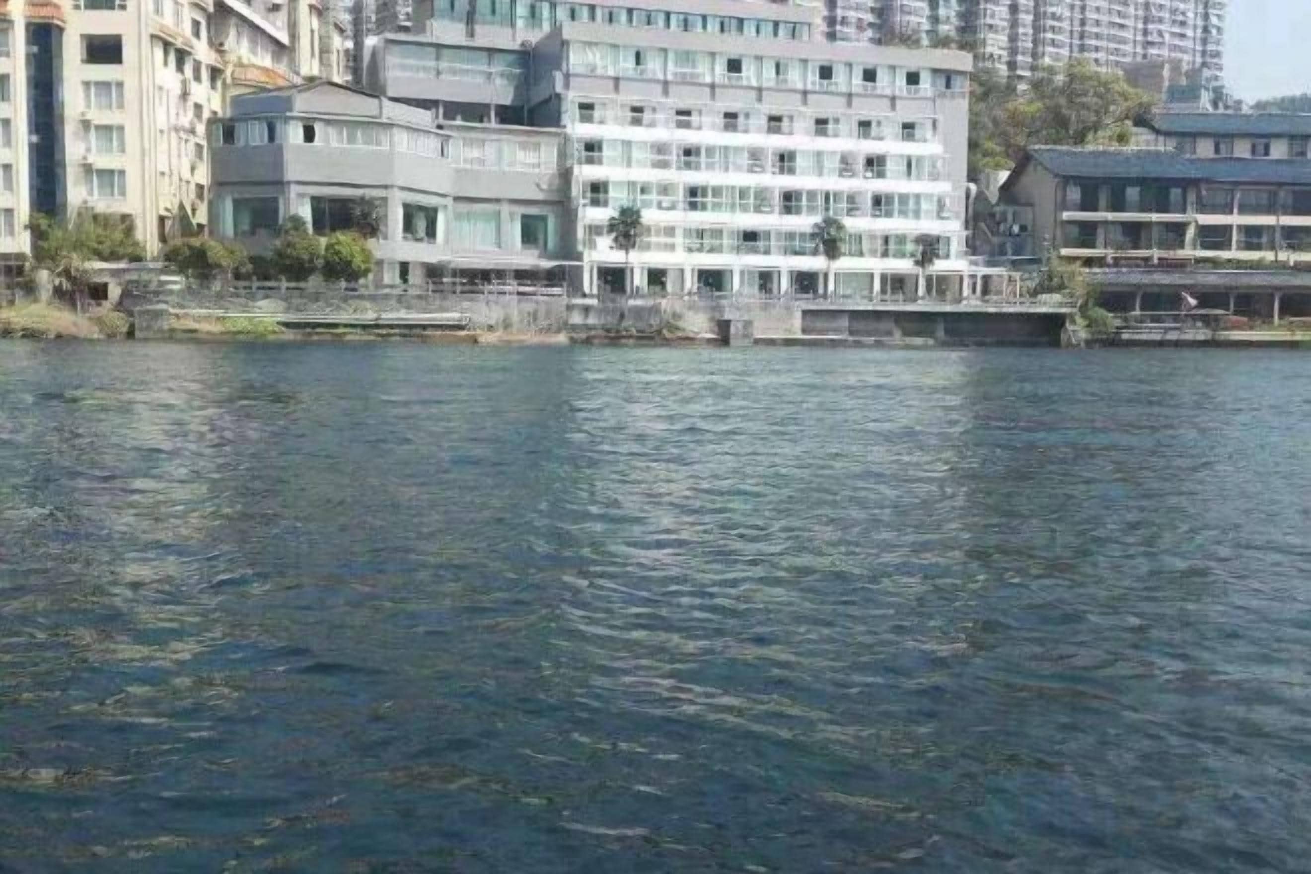 Un hotel frente al agua con varios pisos, un muelle y vistas al mar.