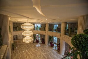 A multi-level atrium with a central spiral chandelier, marble flooring, and multiple seating areas. - Guorui Hotel (Jiande)