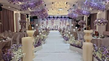 Un espace événementiel élégant, doté d’une allée centrale, d’un éclairage raffiné et de compositions florales.