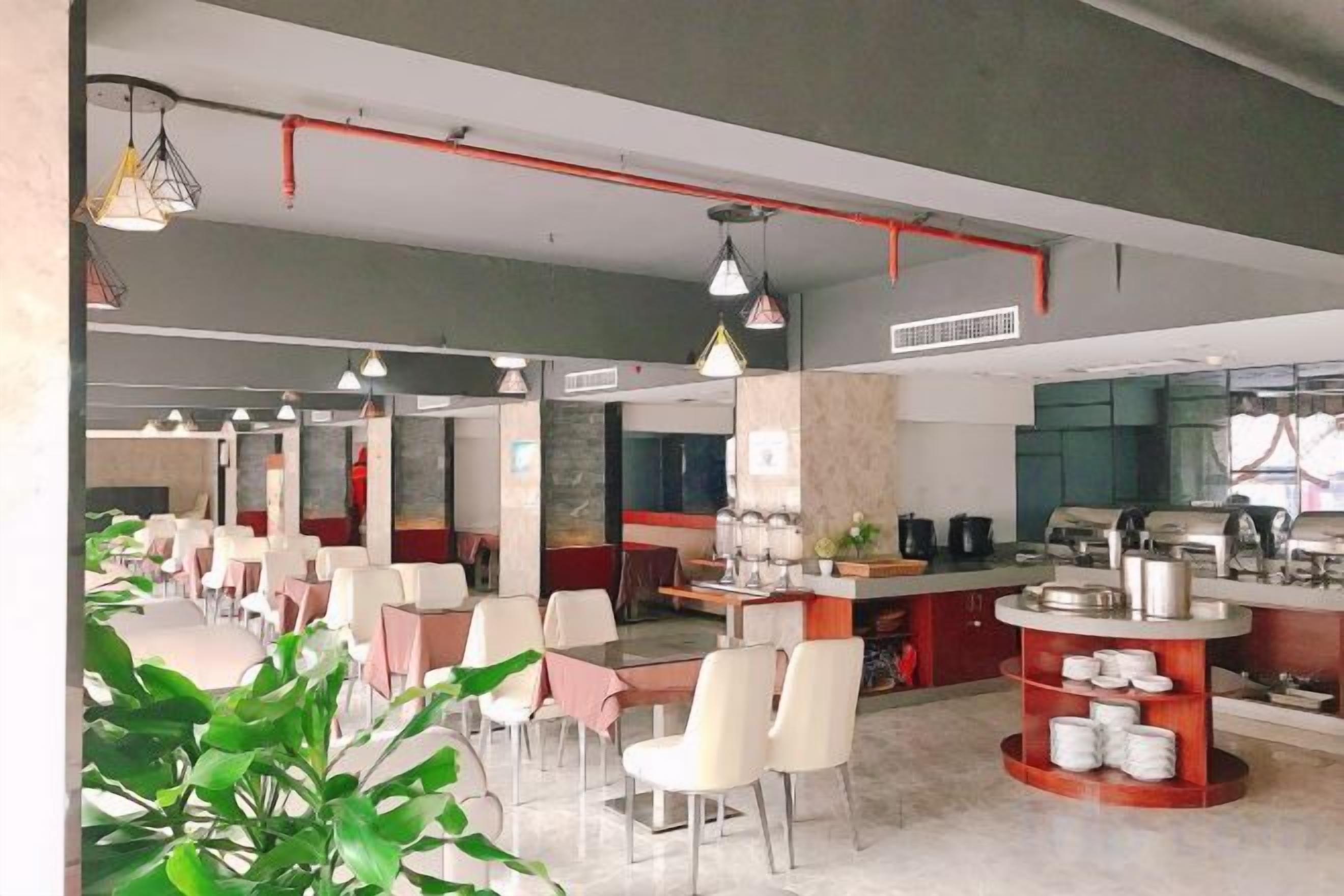 A modern restaurant with multiple dining areas, a kitchen, and a bar area.