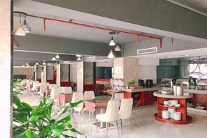 Ein modernes Restaurant mit mehreren Essbereichen, einer Küche und einer Bar.