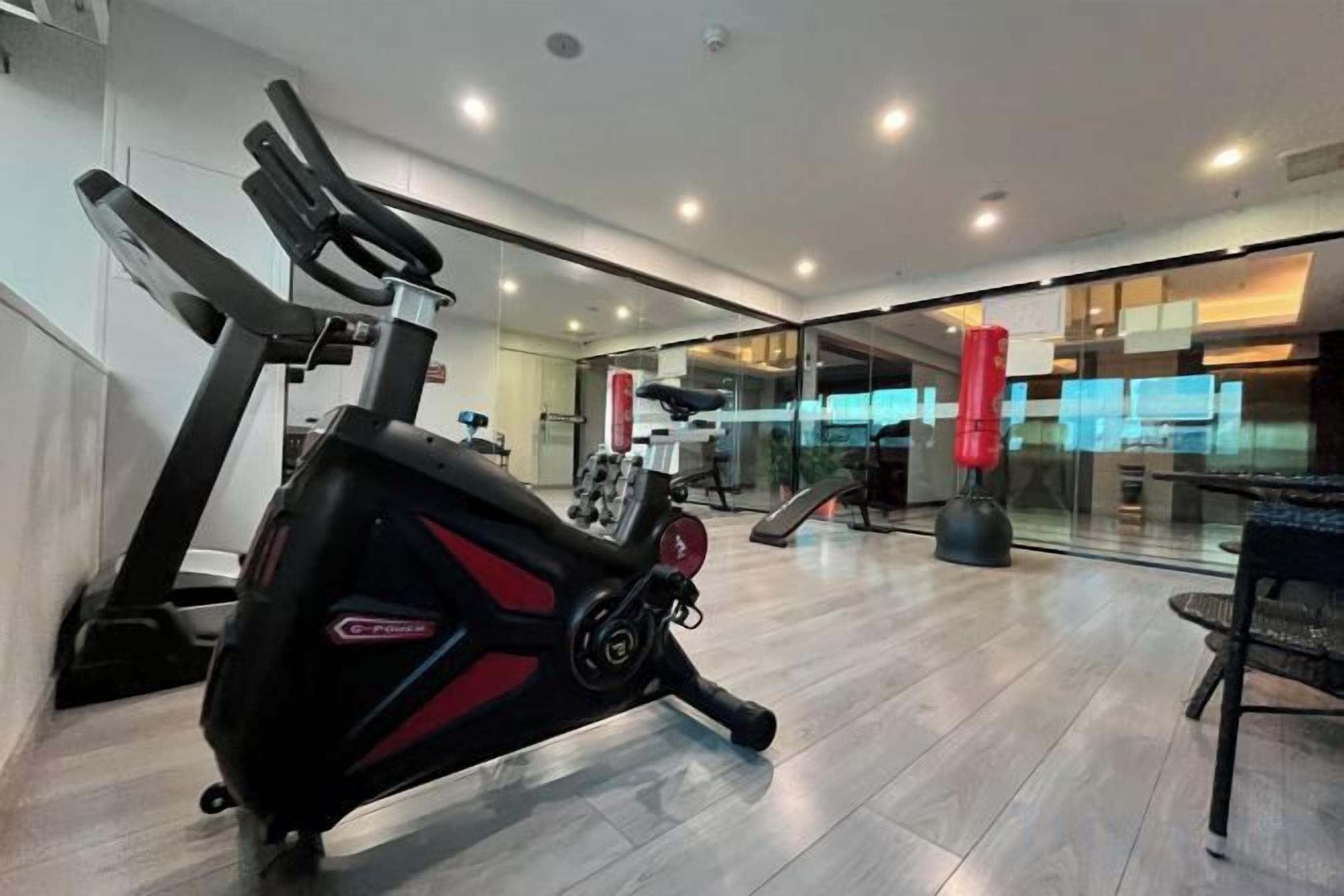 A gym with exercise equipment, a treadmill, and a rowing machine.