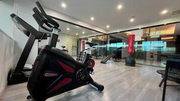 A gym with exercise equipment, a treadmill, and a rowing machine.