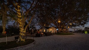 A house with a gravel driveway, surrounded by trees with string lights. - beautiful country house (Clermont)