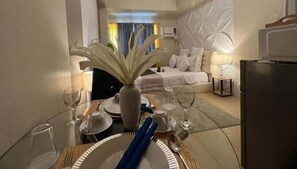 Ett hotellrum med en matplats, en säng och en minibar.
