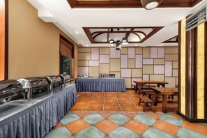 A dining area with a buffet setup, tables, and chairs. - Xinjia Yuquan Hot Spring Hotel (Mile)