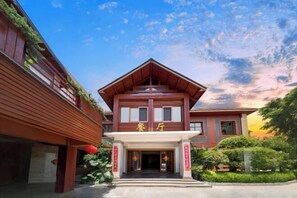A traditional building with a central entrance, a red roof, and a sign with Chinese characters.