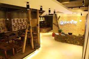 Interior acogedor de un restaurante con mobiliario de madera, una barra de piedra y un ambiente cálido.