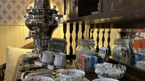 A coffee station with a sign indicating coffee and hot water. - St. George Hotel (Barkerville)