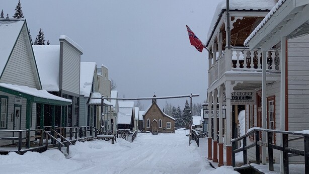 A snow-covered street with buildings, including a church and a building with a sign reading "St. George Hotel". - St. George Hotel (Barkerville)