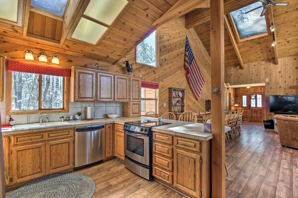 Enjoy cooking in this cabin-style kitchen with a large island, stainless steel appliances, and a dining area.