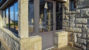 A stone exterior with a large window and a door.