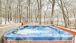 A hot tub in a snowy forest setting.