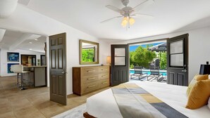 A bedroom with a bed, a dresser, a desk, and a view of a pool. - Modern Oasis w/ Pool, Patio Lounge, & Mountain Views Palo Verde by Avantstay (Palm Springs)