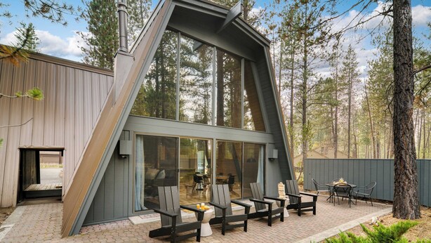 A modern house with a sloped roof and large windows, surrounded by a forest. - Alder by Avantstay Hot Tub + Fireplace + Foosball Loft + Patio Grill Walk to Sunriver Village + Trails + Mt. Bachelor 30 Min (Bend)