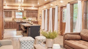 A wooden cabin interior with a kitchen, dining area, and living room. - Bluestem & Bluebell by Avantstay Incredible Views w/ Large Balcony & Indoor Pool! (Sevierville)