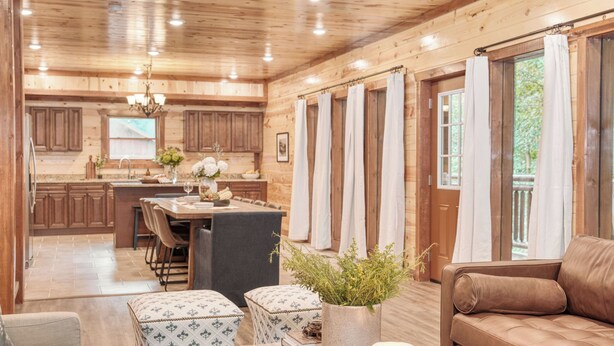 A wooden cabin interior with a dining area, kitchen, and living room. - Bluestem & Bluebell by Avantstay Incredible Views w/ Large Balcony & Indoor Pool! (Sevierville)