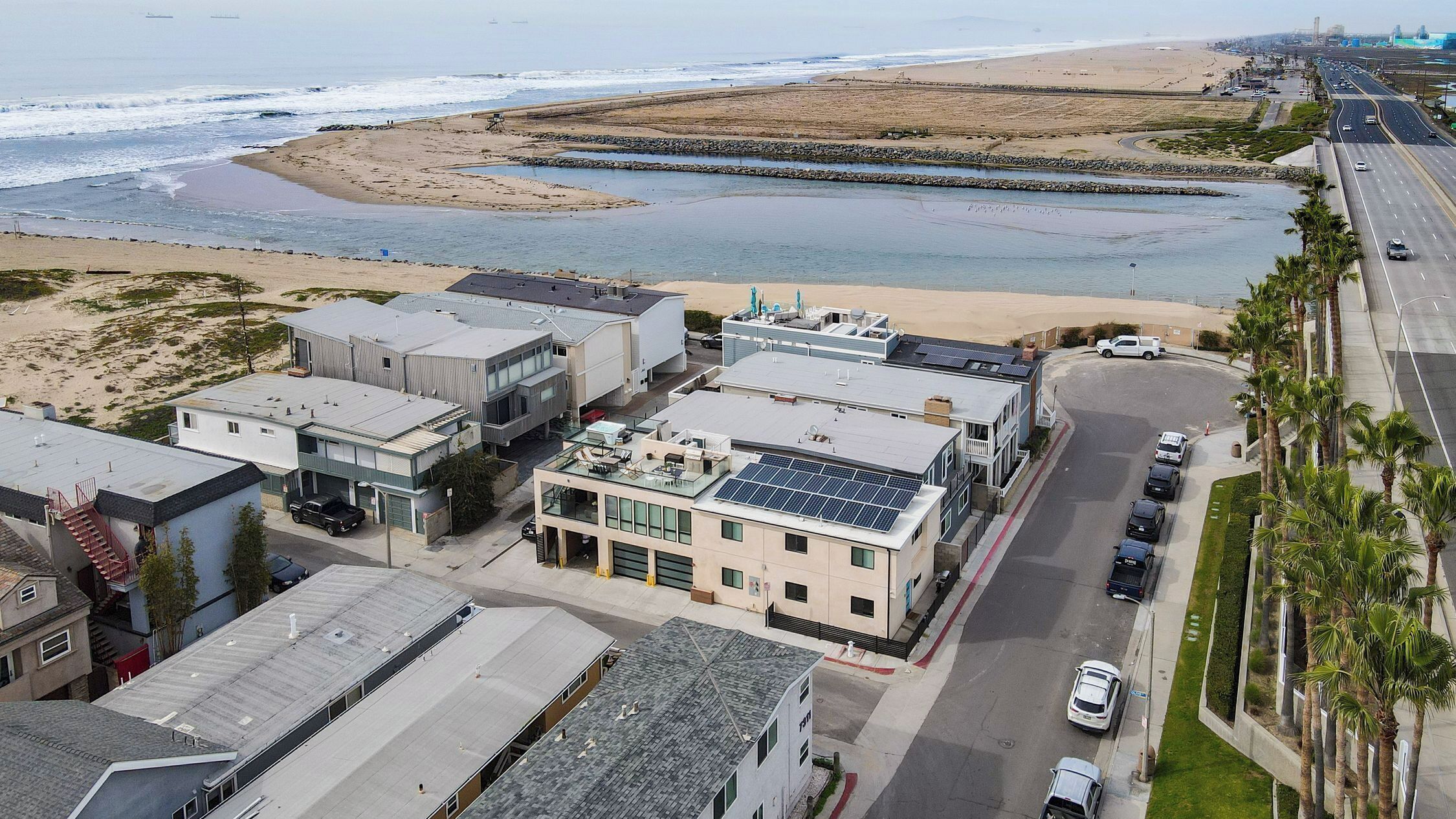 Een kustplaats met moderne gebouwen, een strand en een weg.